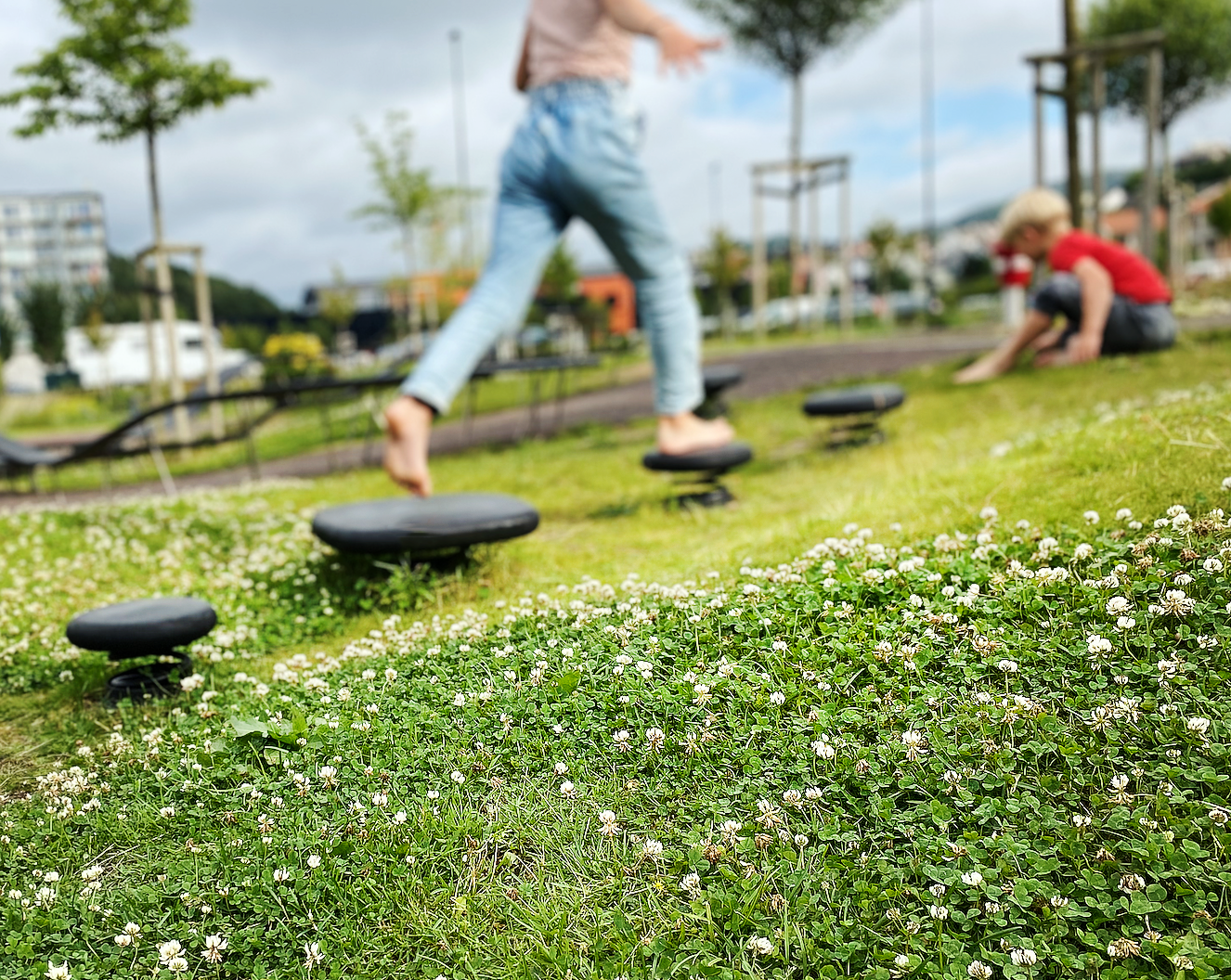 lekeapparater montert i gress, løype med hoppesteiner fra Rampline på lekeplass på Ålgård torg